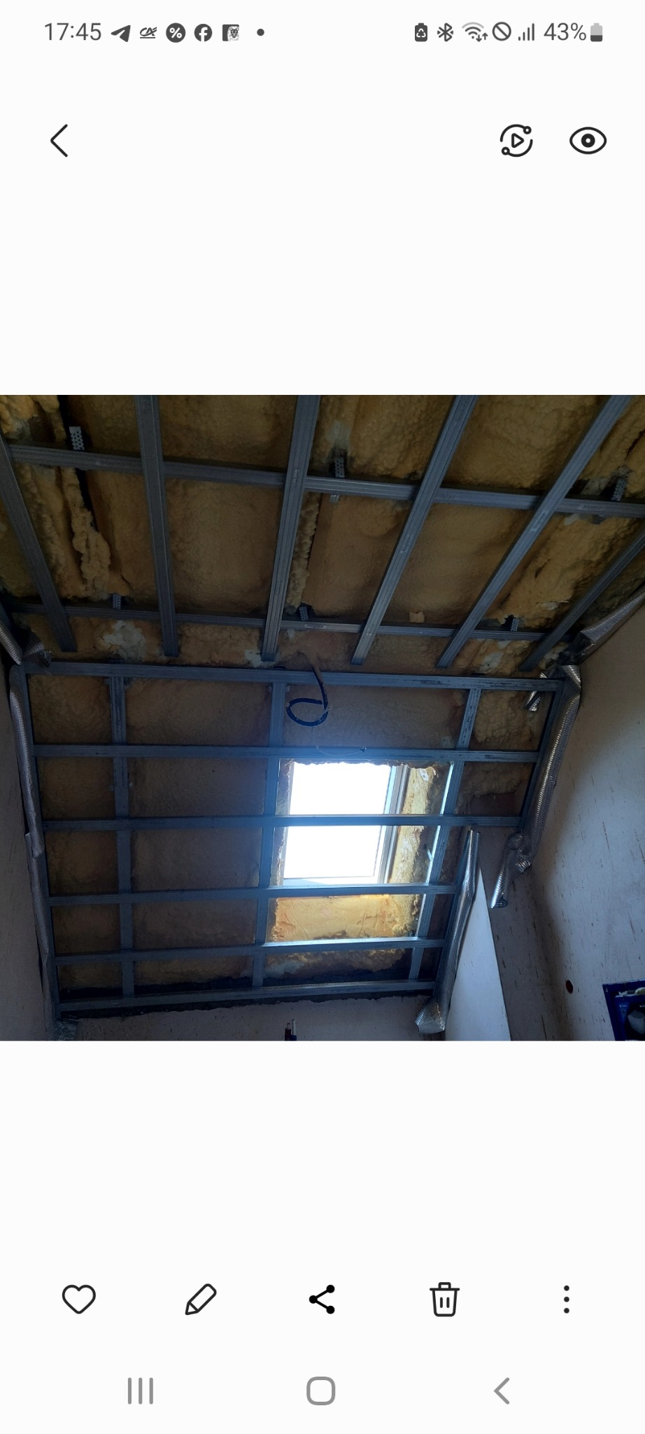 Szkielet sufitu podwieszanego z izolacją z wełny mineralnej, widoczne profile metalowe i fragment wentylacji. Prace wykończeniowe w trakcie realizacji.