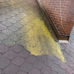 MatGras - Dach pokryty bitumiczną dachówką, częściowo porośnięty mchem, z widocznym kominem z cegły i rynną.