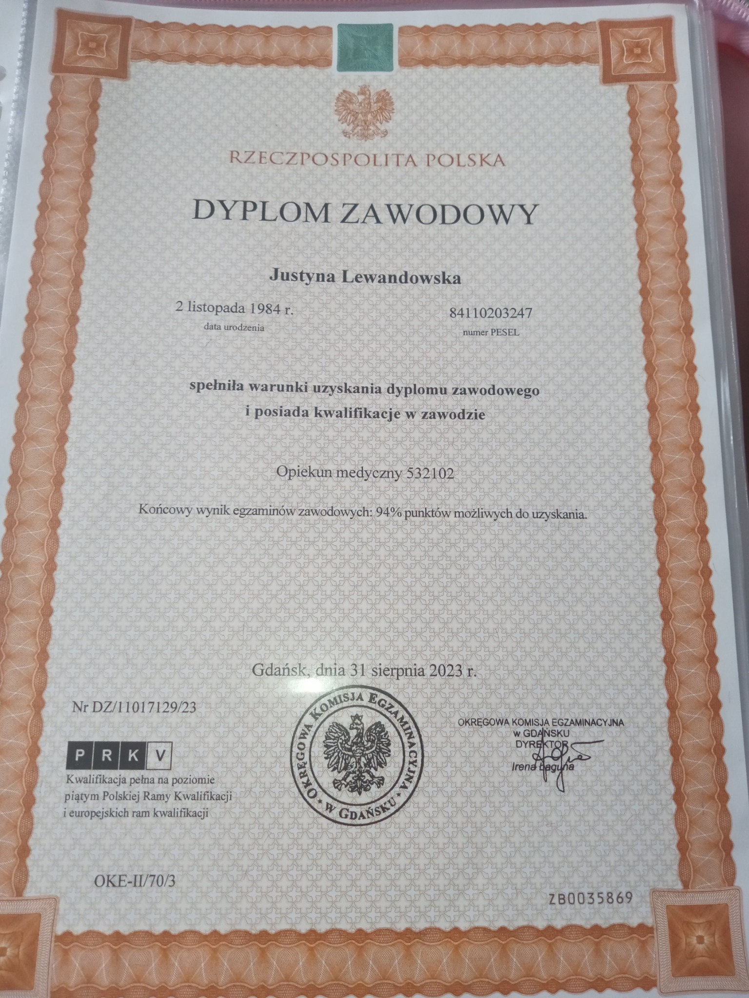 Dyplom zawodowy Justyny Lewandowskiej jako opiekuna medycznego, wydany w Gdańsku, z wynikiem 94% punktów.