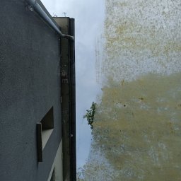 Czyszczenie kostki i elewacji - Porównanie fragmentu elewacji budynku przed i po czyszczeniu, widoczne wyraźne różnice w kolorze i czystości.