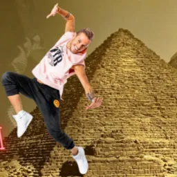 Grafika reklamowa Zumba Online 'Pod Piramidami' z uśmiechniętym instruktorem w skoku na tle egipskich piramid, informacja o dacie i godzinie wydarzenia oraz logo Zumba Fitness i Milh Usen Dance...