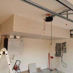 Karol P - Wnętrze garażu w trakcie adaptacji: zabudowa z płyt gipsowo-kartonowych pod sufitem, widoczny system wentylacyjny z rekuperacją, rozdzielnia elektryczna z okablowaniem, drabina aluminiowa...