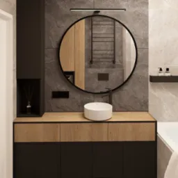 Nowoczesna aranżacja łazienki w Krakowie. Umywalka nablatowa, okrągłe lustro i drewniane akcenty tworzą elegancki wystrój.