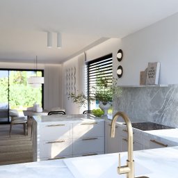 ASthetic form - Jasna kuchnia z wyspą i złotą armaturą. Minimalistyczny design z marmurowym blatem i roślinami. Widok na salon i ogród przez okno.