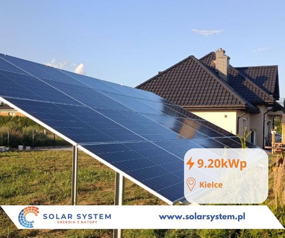 Panele słoneczne zamontowane na ziemi przed domem jednorodzinnym, z widocznym logo firmy Solar System i informacją o mocy instalacji 9.20kW w Kielcach.