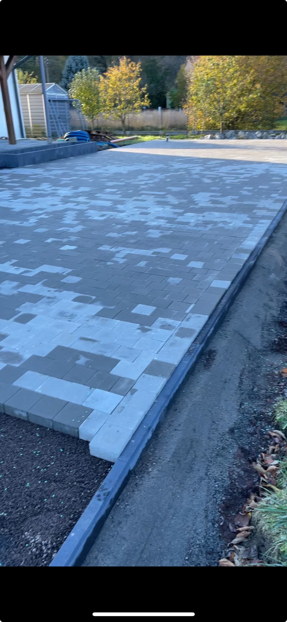 Układanie mozaiki z kostki brukowej w Jeleniej Górze, widok na fragment placu z szarej kostki i obrzeża rabaty z ziemią.