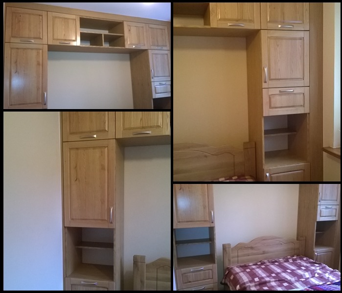 Zabudowa drewniana w sypialni, obejmująca szafki wiszące nad łóżkiem i szafki boczne z półkami i szufladami, wykonana z jasnego drewna z widocznym usłojeniem i srebrnymi uchwytami.