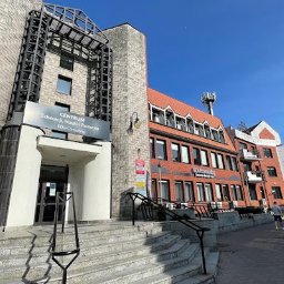 EDU-Consulting SZKOLENIA I DORADZTWO Anna Wiechowska, Danuta Namiak - spółka cywilna - Fasada budynku Centrum Edukacji, Nauki i Rozwoju EDU-Consulting z wejściem po schodach, widok z dołu w słoneczny dzień.