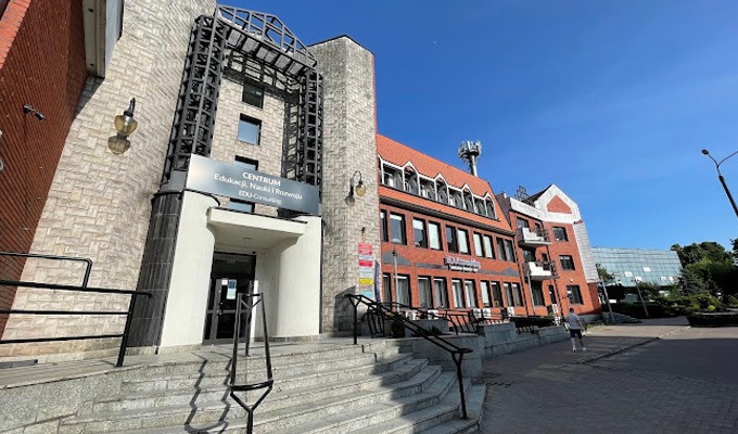 Fasada budynku Centrum Edukacji, Nauki i Rozwoju EDU-Consulting z wejściem po schodach, widok z dołu w słoneczny dzień.