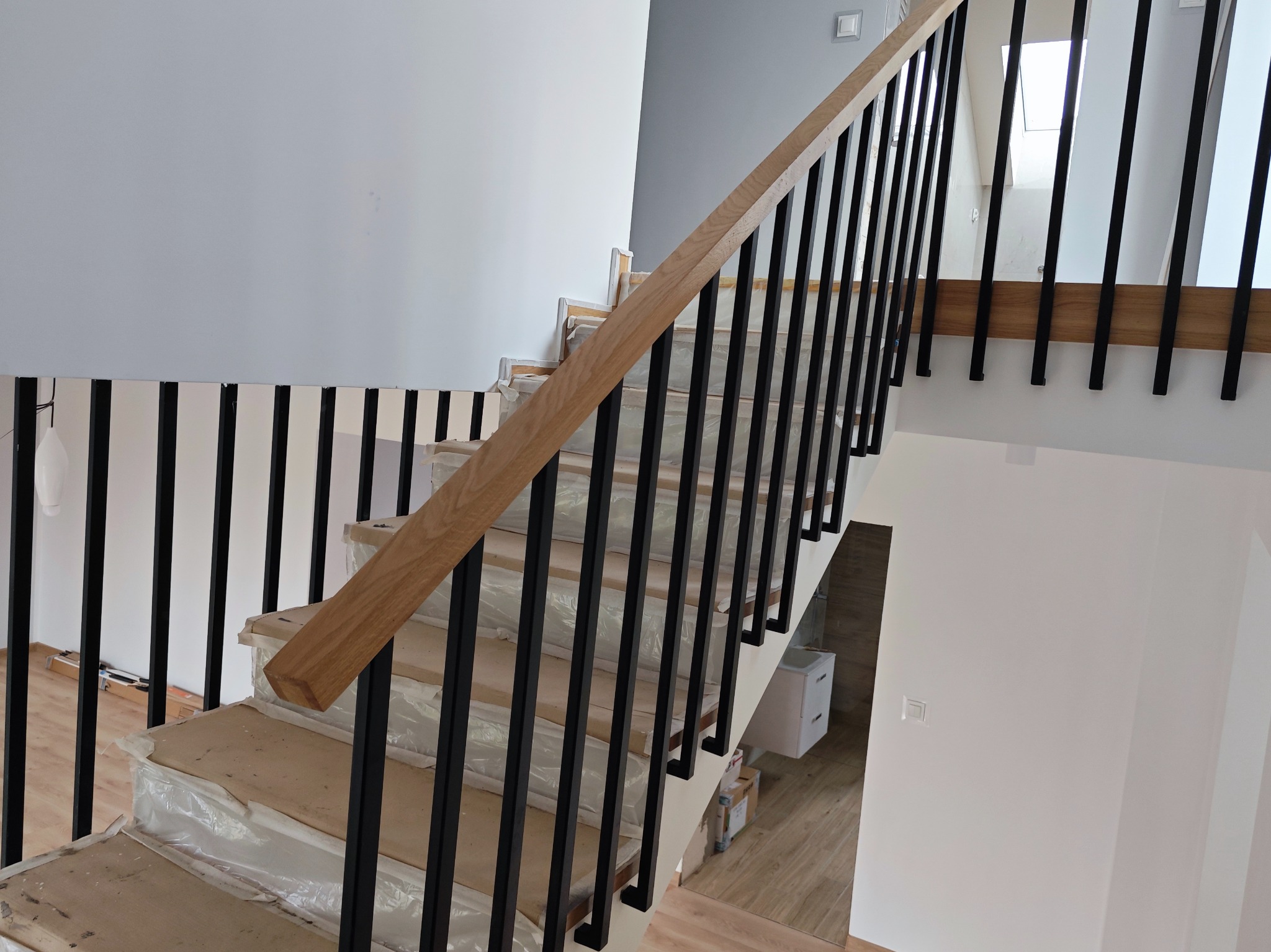 Balustrada stalowa z wykończeniem dębowym.