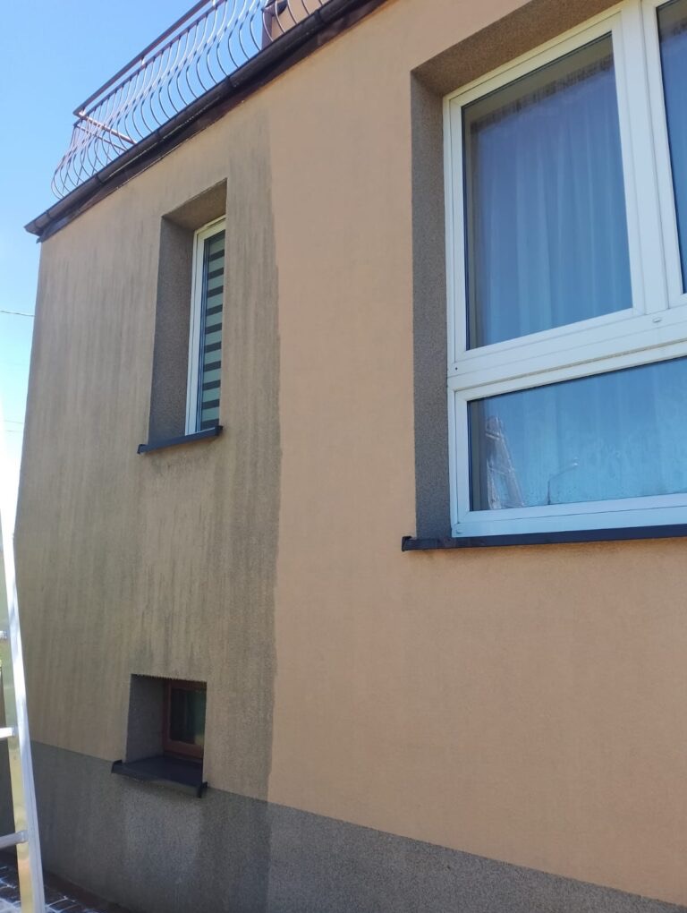 Fragment elewacji budynku z widoczną różnicą w czystości, ukazując efekt przed i po myciu. Widoczne okna i balkon z metalową balustradą.