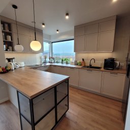 Serce domu w nowoczesnym wydaniu
Jasna, przestronna kuchnia łącząca nowoczesną elegancję z przytulnym klimatem. Stonowane, jasne fronty idealnie współgrają z drewnianymi blatami. Duża wyspa kuchenna to idealne miejsce na poranną kawę