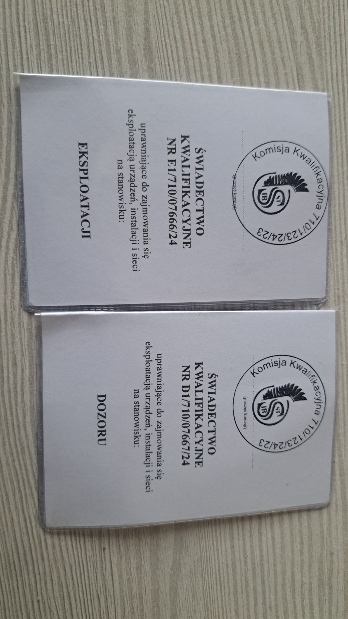 Dwa świadectwa kwalifikacyjne uprawniające do zajmowania się eksploatacją urządzeń, instalacji i sieci na stanowisku dozoru i eksploatacji, z pieczęcią komisji kwalifikacyjnej.