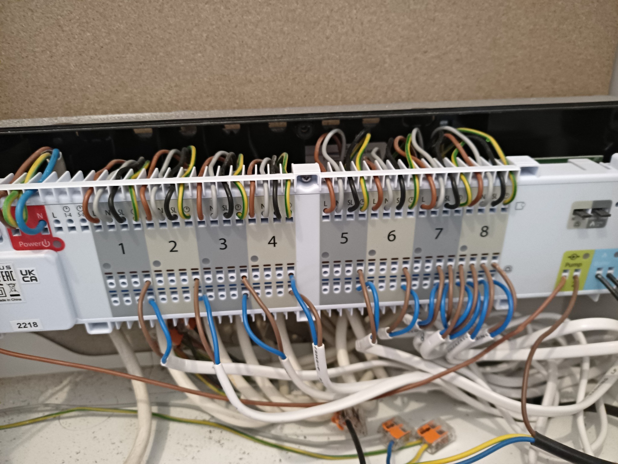 Rozdzielnica elektryczna z podłączonymi przewodami o różnych kolorach, widoczne złącza WAGO i oznaczenia numerów od 1 do 8, instalacja w trakcie podłączania.