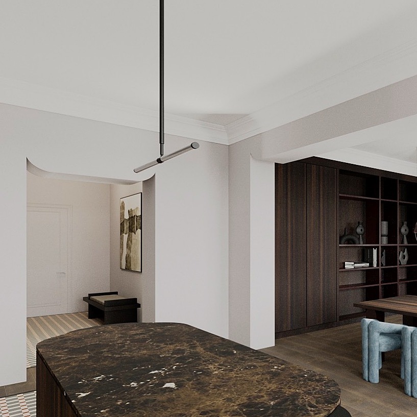 Wnętrze z marmurowym blatem wyspy kuchennej, minimalistyczną lampą wiszącą, ciemną biblioteczką i abstrakcyjnym obrazem w przejściu.