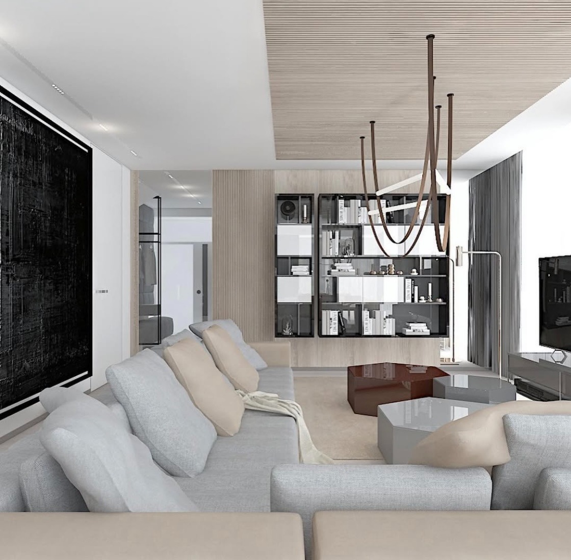 Nowoczesny salon z szarą sofą modułową, geometrycznymi stolikami kawowymi, regałem z książkami i abstrakcyjnym obrazem w czarnej ramie na ścianie.