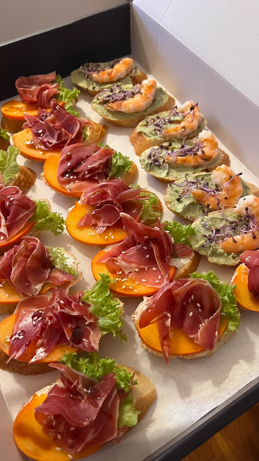 Apetyczne kanapeczki z szynką parmeńską i krewetkami na cateringu w Warszawie. Dekoracyjne ułożenie, świeże składniki, idealne na imprezę.