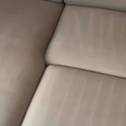 Jasny narożnik po praniu, widoczne ślady po czyszczeniu ekstrakcyjnym, świeżo wyprana tapicerka.