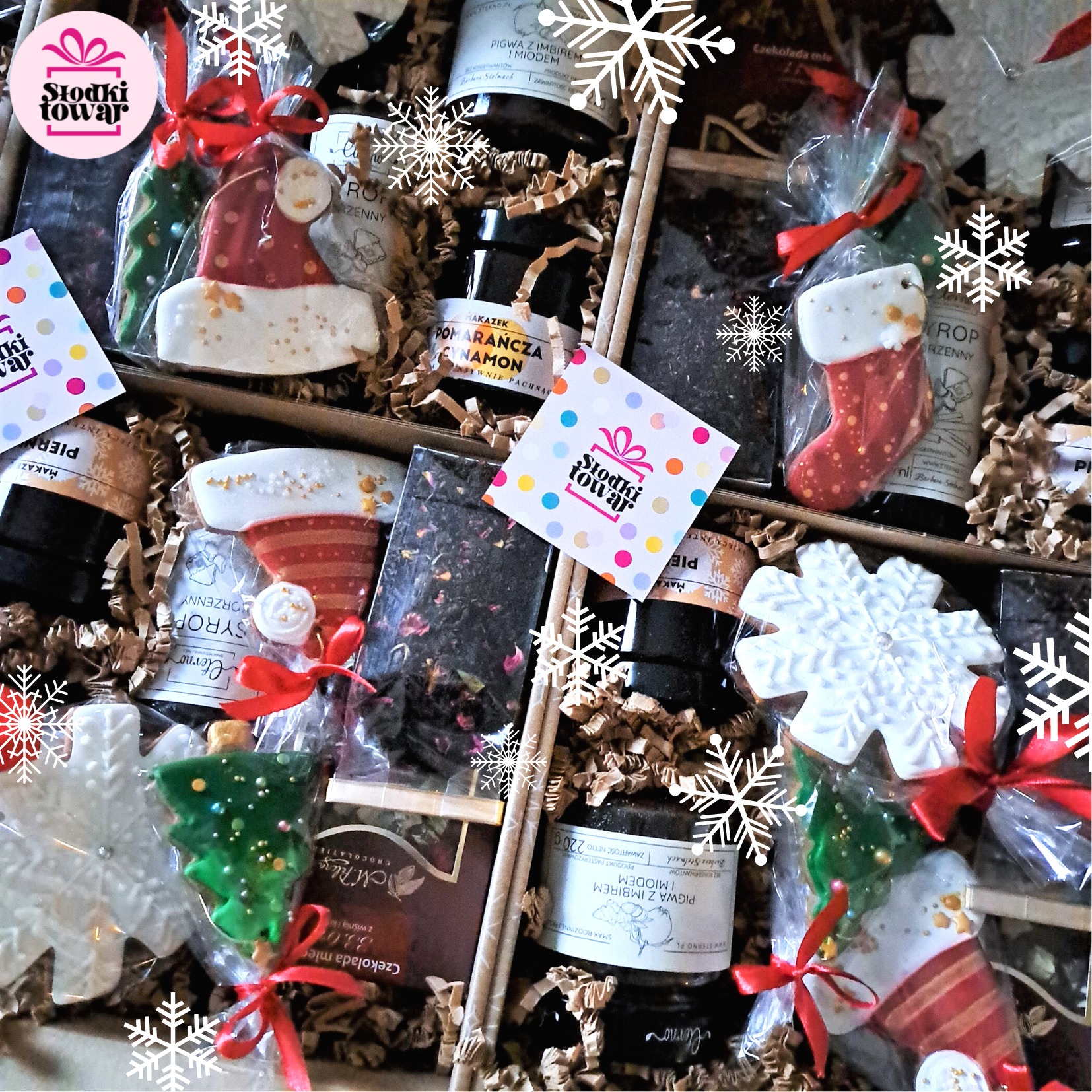 Świąteczny zestaw upominkowy: piernikowe ciasteczka w kształcie choinki, skarpety i czapki Mikołaja, miód z imbirem, czekolada, herbata, wszystko zapakowane w tekturowe pudełko wypełnione wełną...