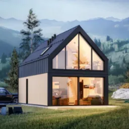 Nowoczesny dom modułowy z czarną blachą na dachu i dużymi przeszkleniami, otoczony zielonym trawnikiem, z paleniskiem i czarnym Land Roverem w tle, na tle górskiego krajobrazu.