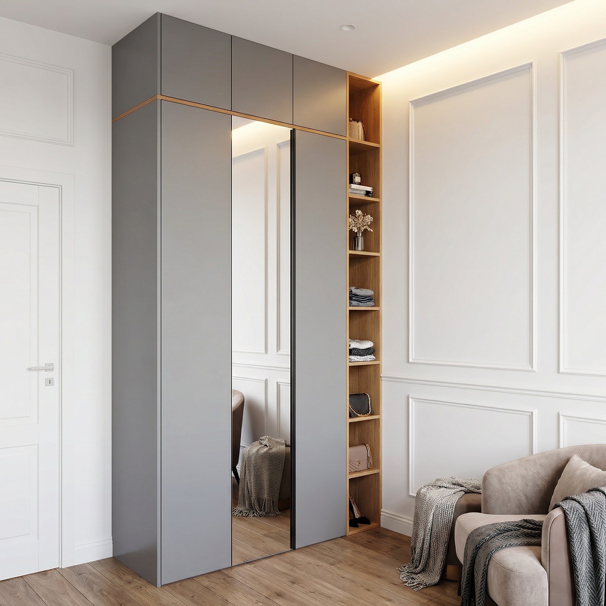 Szara szafa wnękowa z lustrzanymi drzwiami przesuwnymi i drewnianą półką z dekoracjami, w jasnym wnętrzu z drewnianą podłogą i sztukaterią.