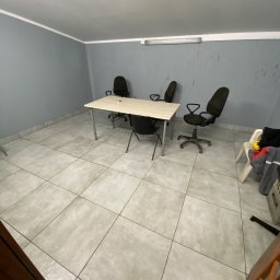 Brak - Puste biuro w Sierpcu z biurkiem i krzesłami na kafelkowej podłodze, przygotowane do sprzątania.