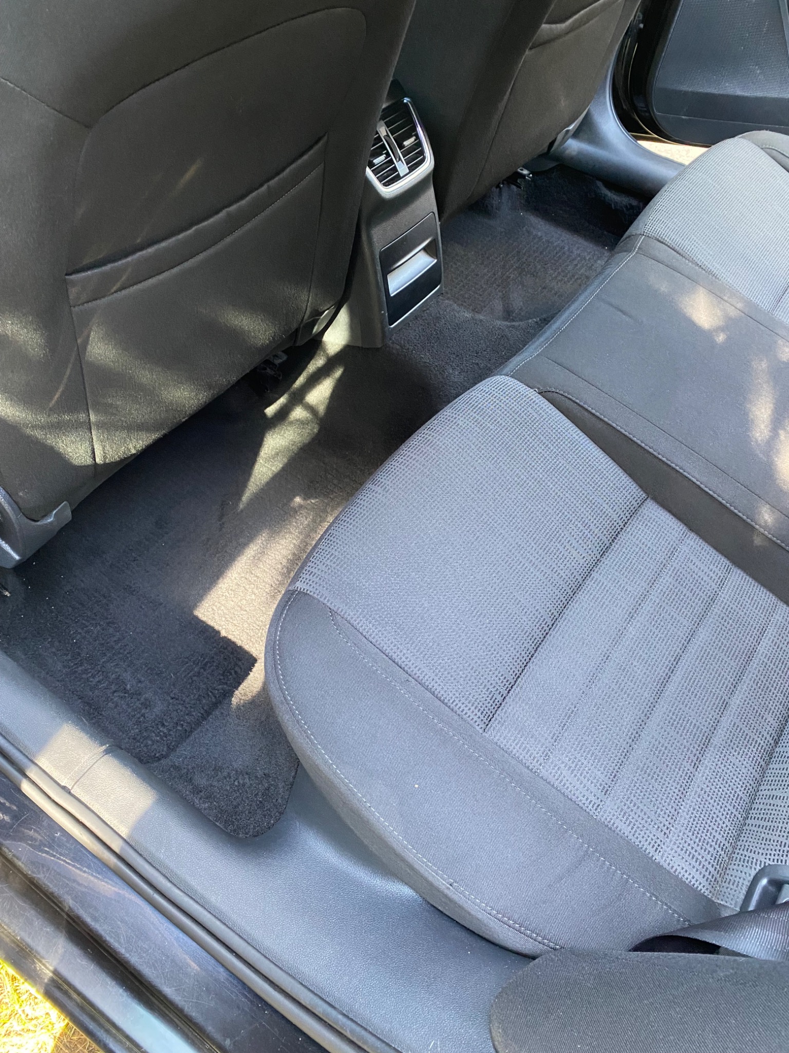 Wnętrze samochodu z widocznym tylnym siedzeniem i podłogą, po praniu, z delikatnymi zacienieniami.