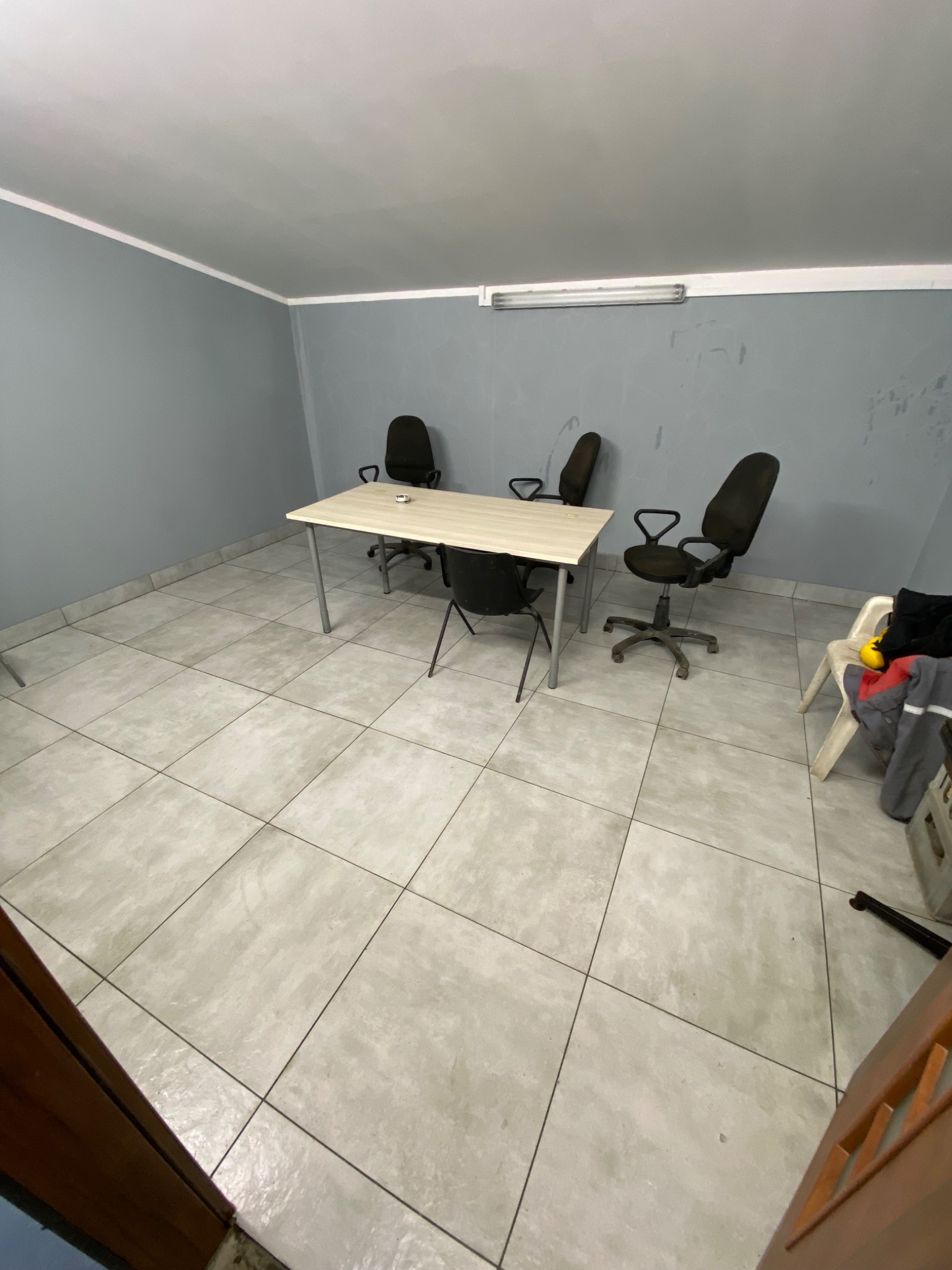 Puste biuro w Sierpcu z biurkiem i krzesłami na kafelkowej podłodze, przygotowane do sprzątania.