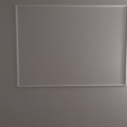 Jacek Brzezicki - Szara ściana z dekoracyjnymi, prostokątnymi ramkami i gniazdkami elektrycznymi w trakcie montażu.