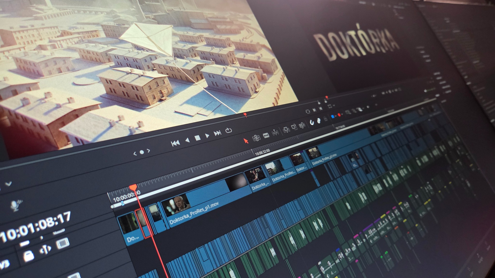 Ekran z oprogramowaniem do edycji wideo, timeline z licznymi ścieżkami, podgląd sceny z animacją 3D osiedla i tytuł 'Doktórka'.