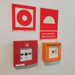 Zestaw oznakowań przeciwpożarowych i przycisków alarmowych na białej ścianie, w tym przycisk Bosch PING.02/113 i panel sterowania oddymianiem z diodą 'DOZÓR OK'.