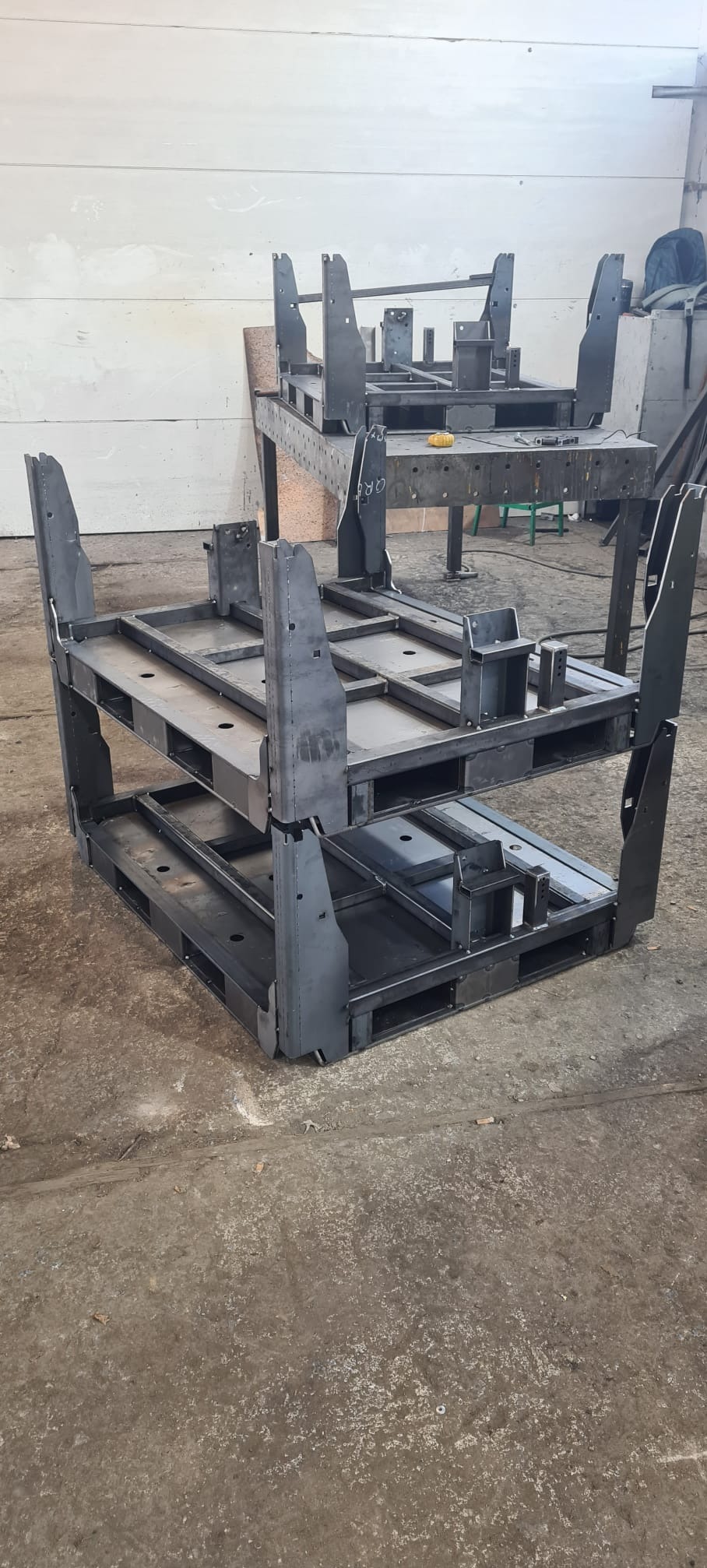 Konstrukcja stalowa z profili zamkniętych, spawana, tworząca paletę wielopoziomową. Widoczne ślady po spawaniu. W tle warsztat.