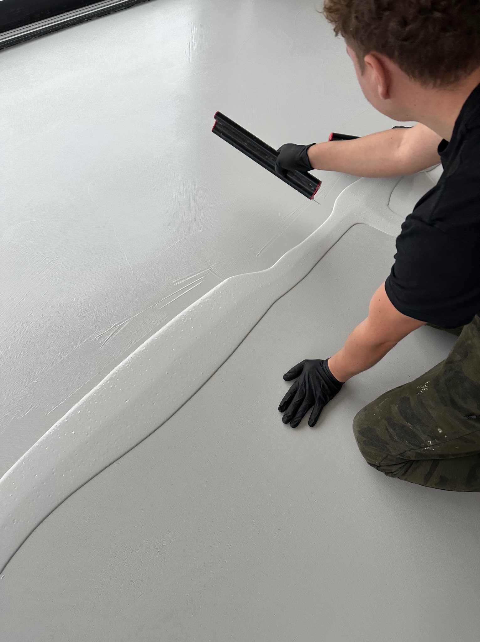 Rozprowadzanie mikrocementu na posadzce.