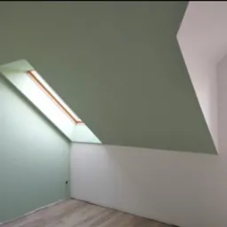 Pomalowane na zielono poddasze ze skośnym sufitem i oknem dachowym. Ściany częściowo białe, widoczne ślady po gniazdkach elektrycznych. Podłoga drewniana.