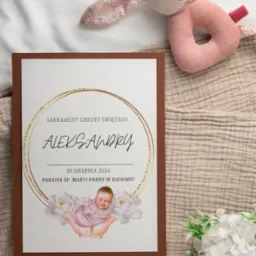 Zaproszenie na chrzest z imieniem Aleksandry, datą 30 sierpnia 2024 i ilustracją dziecka trzymanego w dłoniach, leży obok pluszowego króliczka i białych kwiatów na beżowym tle.