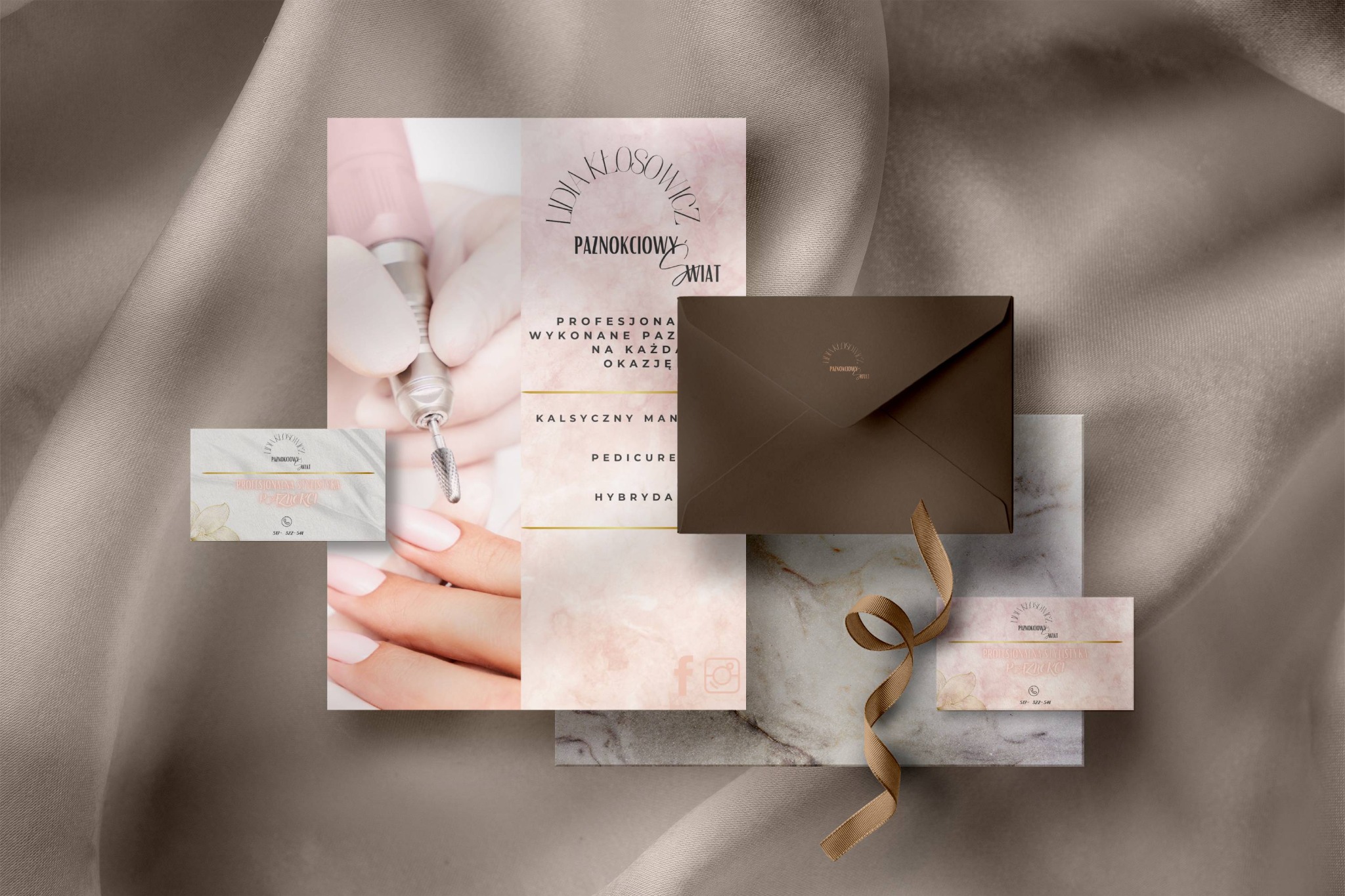Zestaw materiałów reklamowych salonu kosmetycznego: wizytówki z logo, ulotka informacyjna, koperta i wstążka na tle beżowej tkaniny.