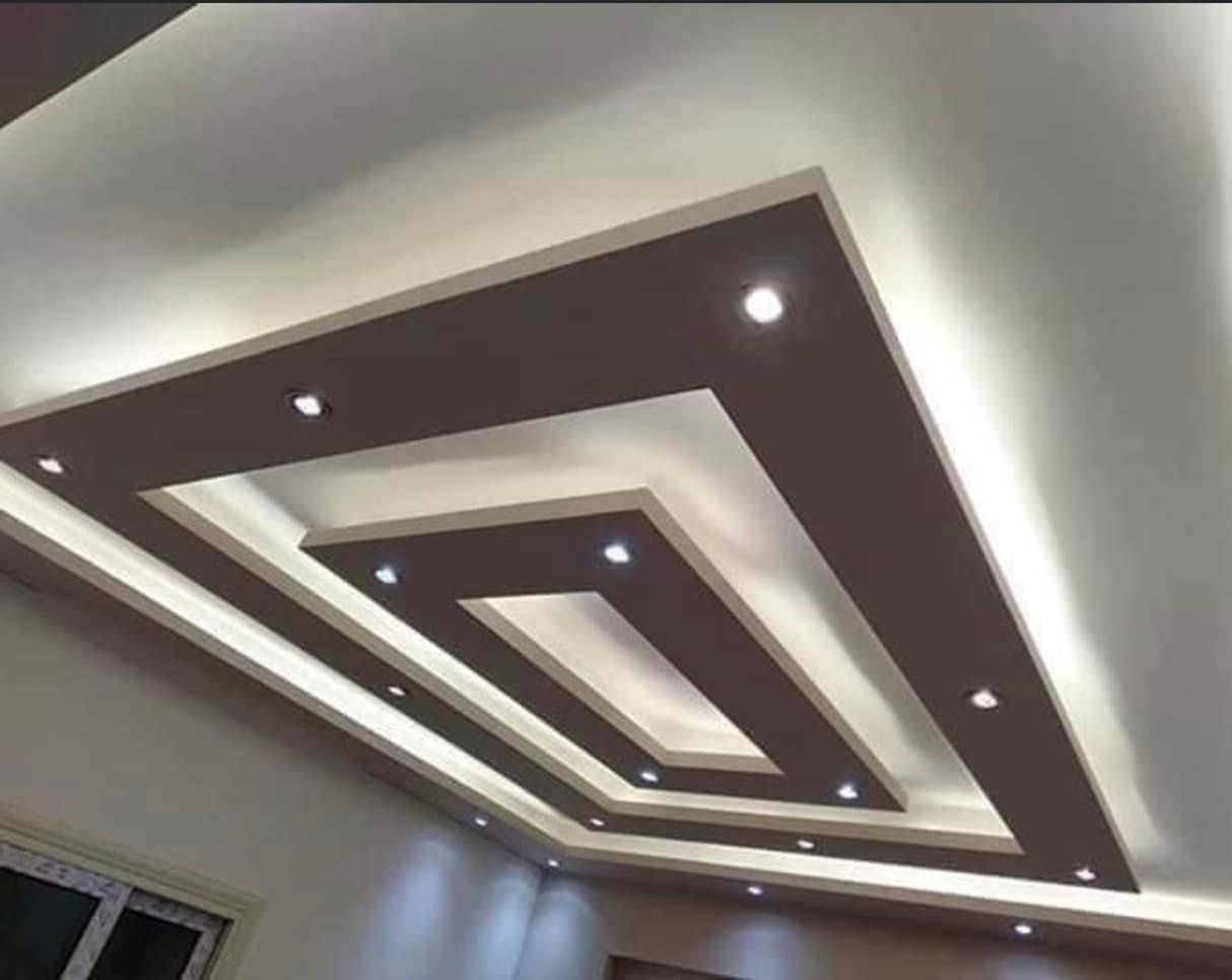 Dekoracyjny sufit podwieszany z płyty karton gips z oświetleniem punktowym i taśmami LED, widok z dołu.