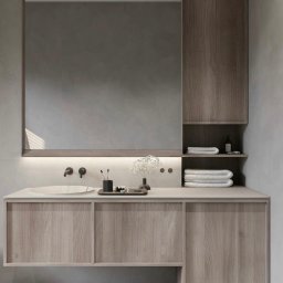 PKN Estate Sp. z o.o. - Nowoczesna łazienka z drewnianą szafką pod umywalką, dużym lustrem z podświetleniem LED i półkami. Minimalistyczny design, neutralna kolorystyka, eleganckie dodatki.
