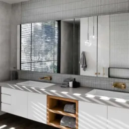 Nowoczesna łazienka z podwójną umywalką, białymi szafkami z drewnianymi półkami i lustrami na tle szarych, pionowych płytek. Minimalistyczny design z akcentami złota.