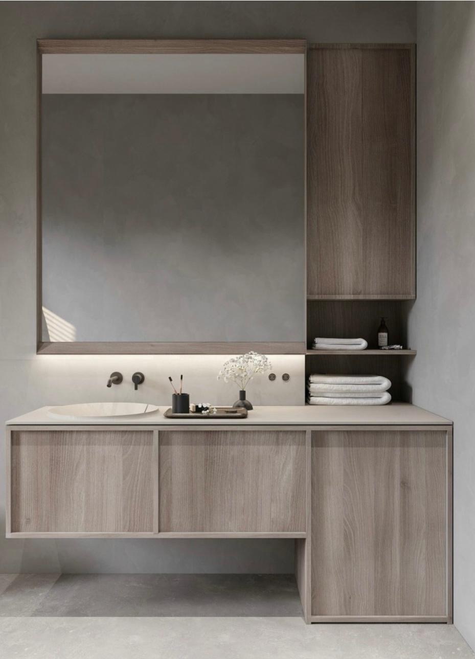 Nowoczesna łazienka z drewnianą szafką pod umywalką, dużym lustrem z podświetleniem LED i półkami. Minimalistyczny design, neutralna kolorystyka, eleganckie dodatki.