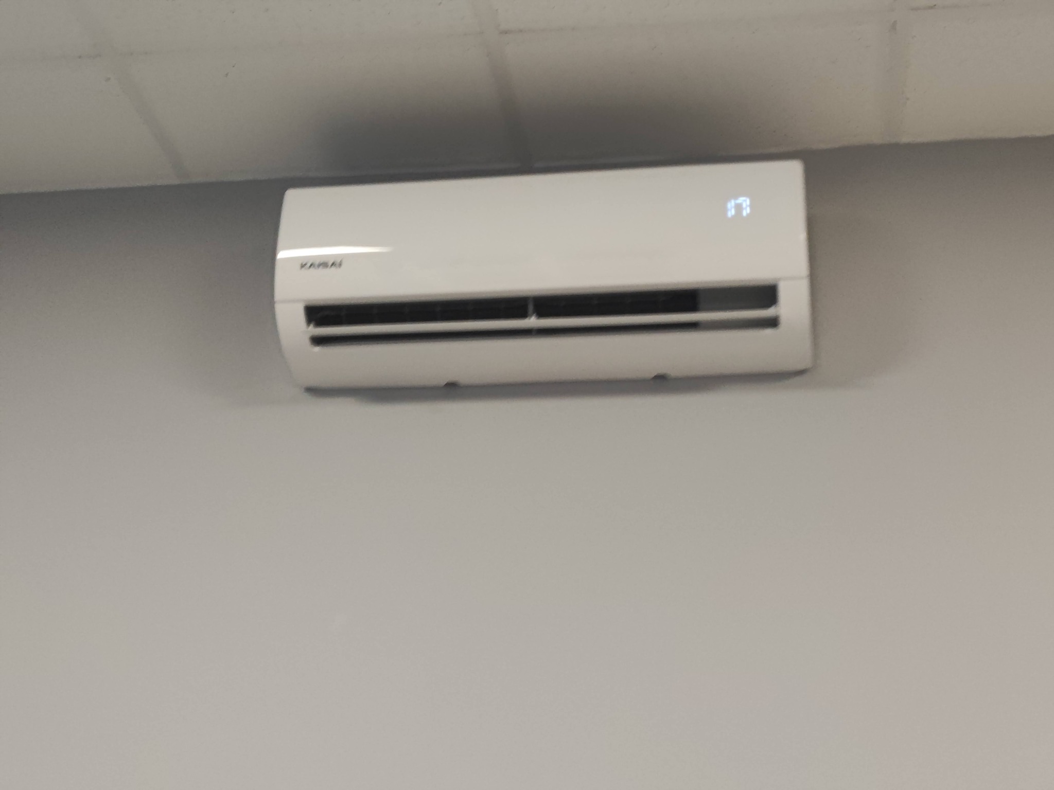 Biała jednostka klimatyzacji marki Kaisai zamontowana na szarej ścianie w Bielawie, wyświetlająca temperaturę 17 stopni Celsjusza.