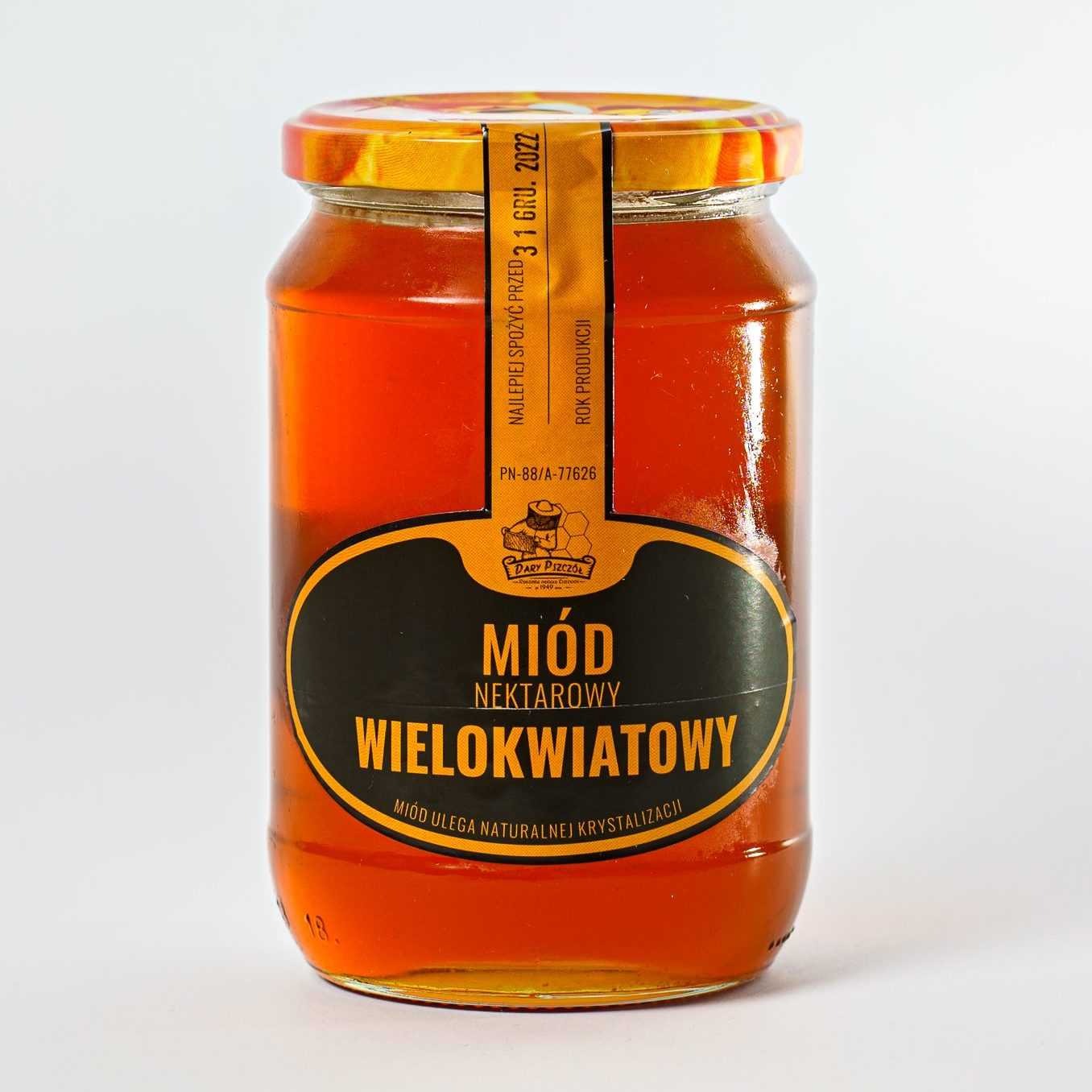 Słoik miodu nektarowego wielokwiatowego z etykietą informującą o dacie ważności do 31 grudnia 2022 roku, na białym tle.