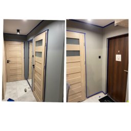 Mateusz Adamczewski - Korytarz zabezpieczony taśmą malarską przed malowaniem ścian na szaro, widoczne drewniane drzwi z przeszkleniami i ciemne drzwi wejściowe z dekoracją.