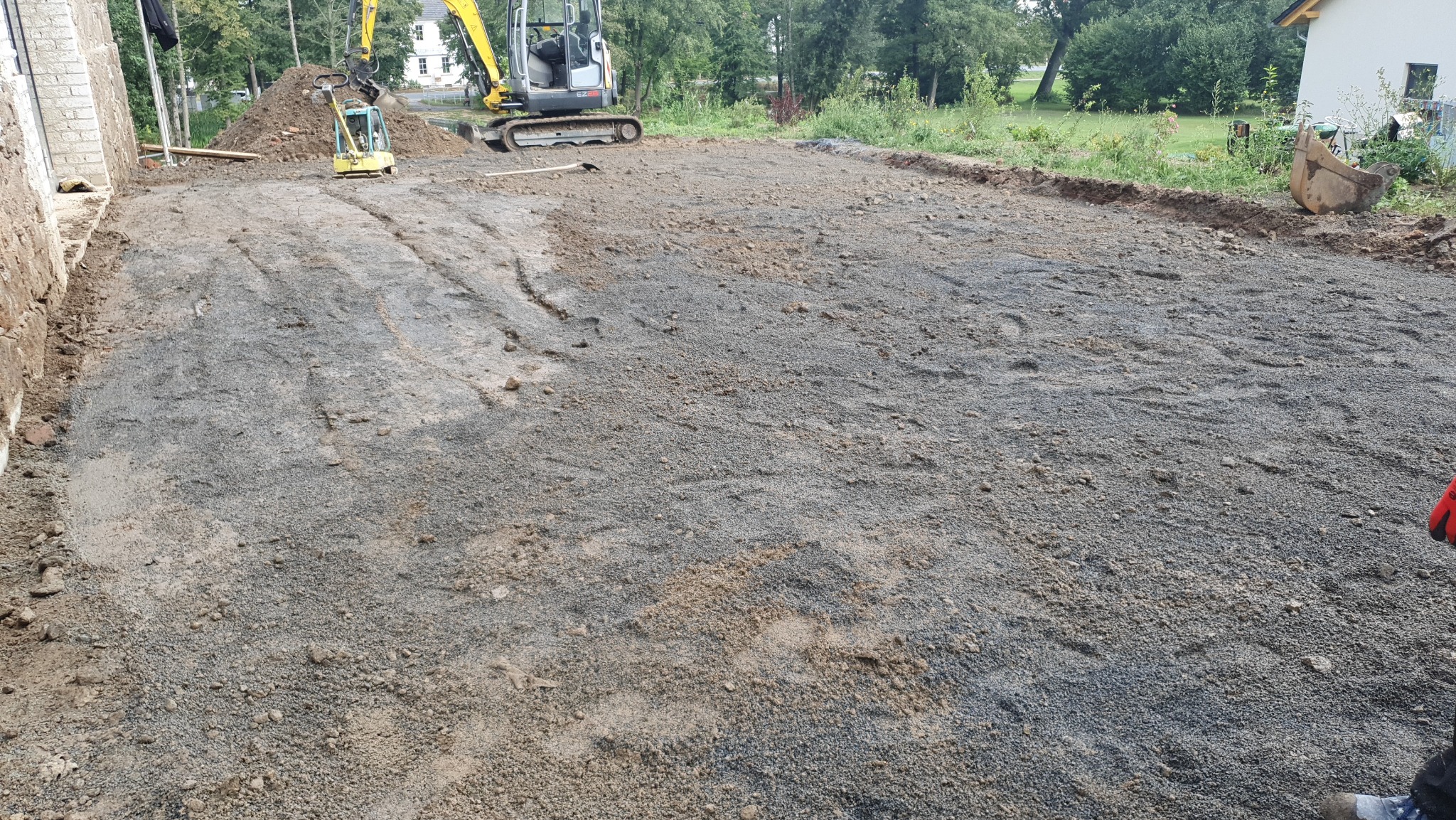 Przygotowany teren pod budowę w Görlitz, widoczne maszyny budowlane i warstwa utwardzającego kruszywa.