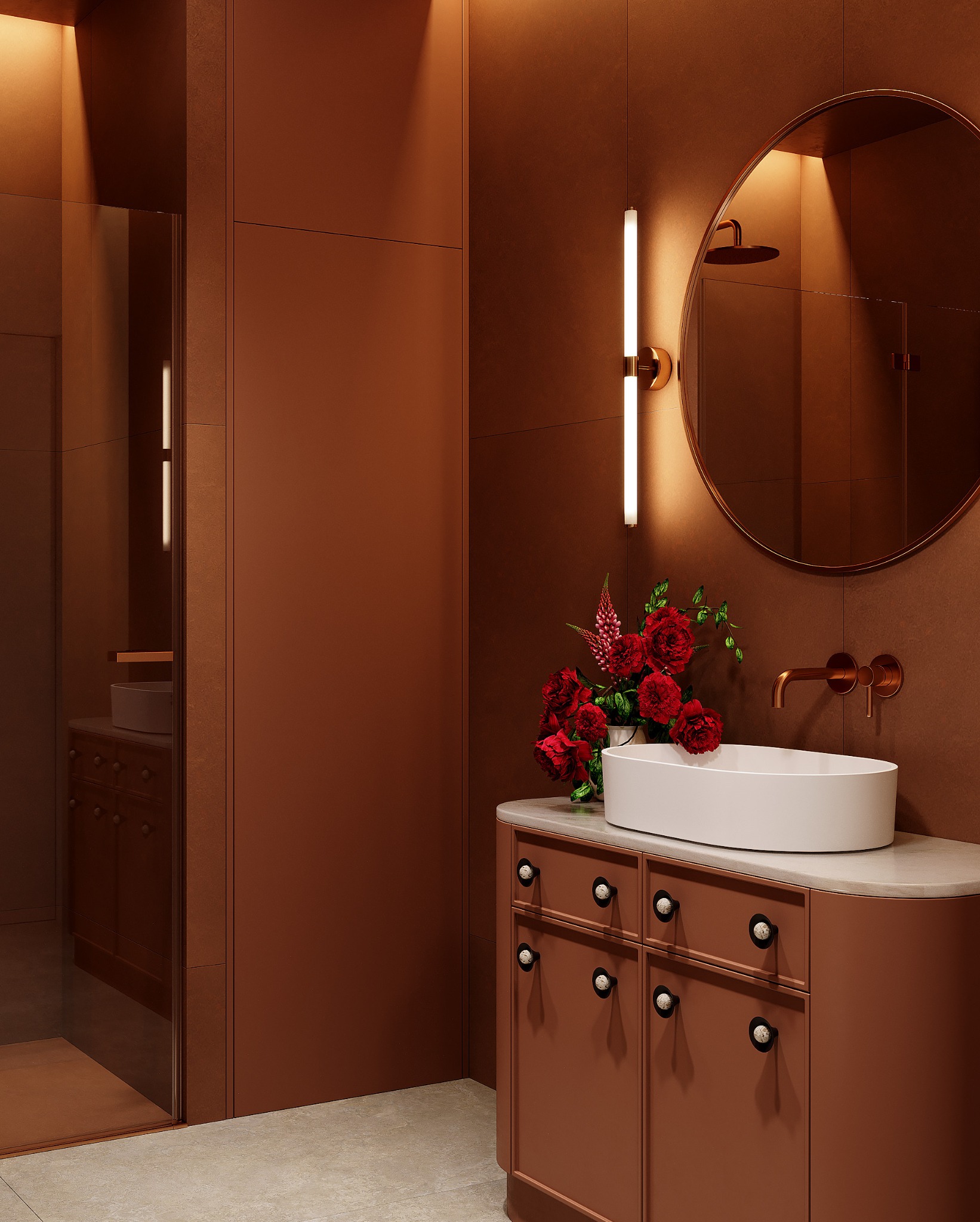 Miedziana łazienka z owalną umywalką, okrągłym lustrem i bukietem czerwonych róż. Minimalistyczny design, ciepłe oświetlenie, widoczny fragment kabiny prysznicowej.