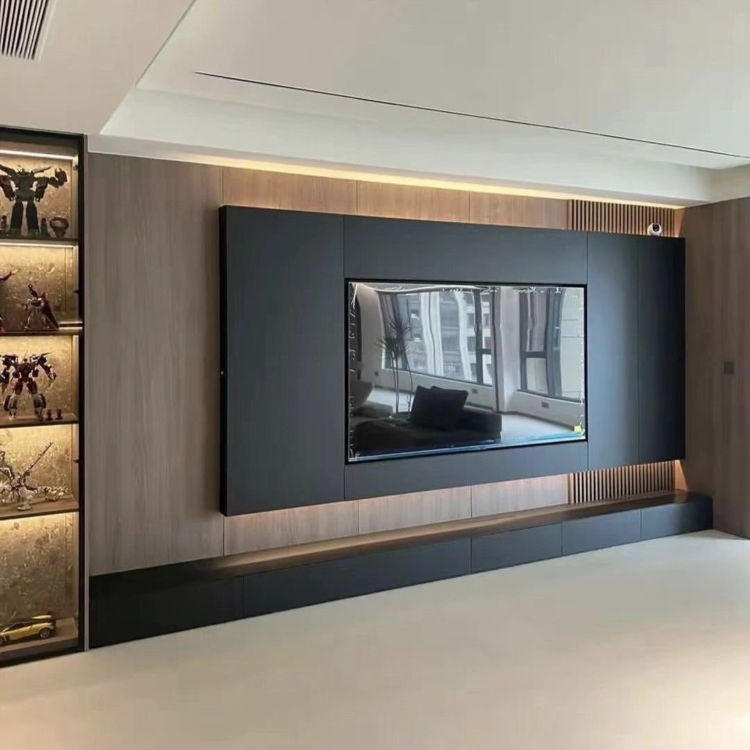 Nowoczesna ściana telewizyjna z wbudowanymi szafkami i oświetleniem LED, obok przeszklona witryna z modelami robotów, minimalistyczny design.