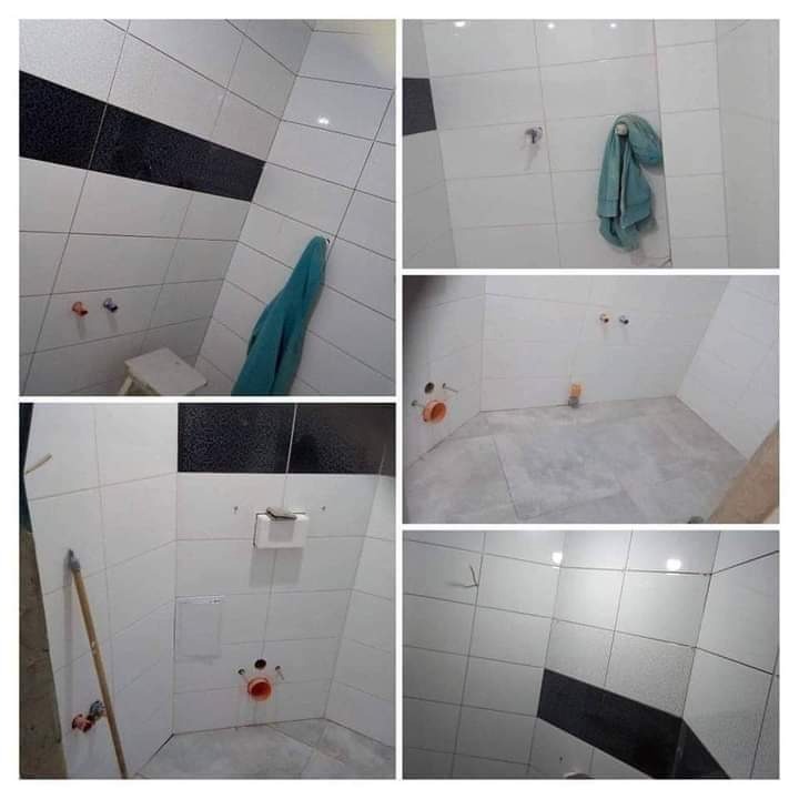 Kolaż zdjęć przedstawiający łazienkę w trakcie prac wykończeniowych: ułożone białe płytki z czarnymi akcentami, widoczne instalacje wodno-kanalizacyjne, fragment drabiny oparty o ścianę, ręcznik...