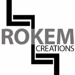 Logo firmy Rokem Creations, stylizowane litery tworzące abstrakcyjny kształt, nazwa firmy w szarym kolorze, czarne elementy graficzne.
