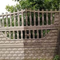 Fragment ogrodzenia z betonu architektonicznego, z wyraźną różnicą między czystą, jasną częścią po lewej i brudną, ciemną częścią po prawej stronie, ukazując efekt przed i po czyszczeniu...