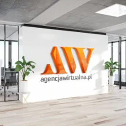 Wnętrze biura z logo 'agencjawirtualna.pl' na ścianie, rośliny doniczkowe, widok na miasto przez okno.